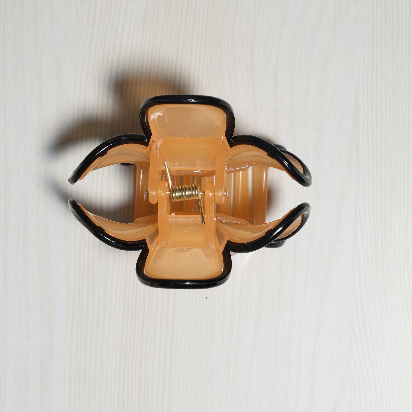 Beige and black hair claw clip with spring mechanism resembling Pearl Finish Single Flower Clutch