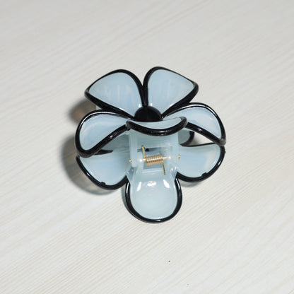Pearl Finish Single Flower Clutch hair clip with black edges on light surface