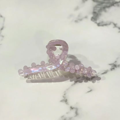 Light pink pearl floral hair clutches with a translucent finish on marble background