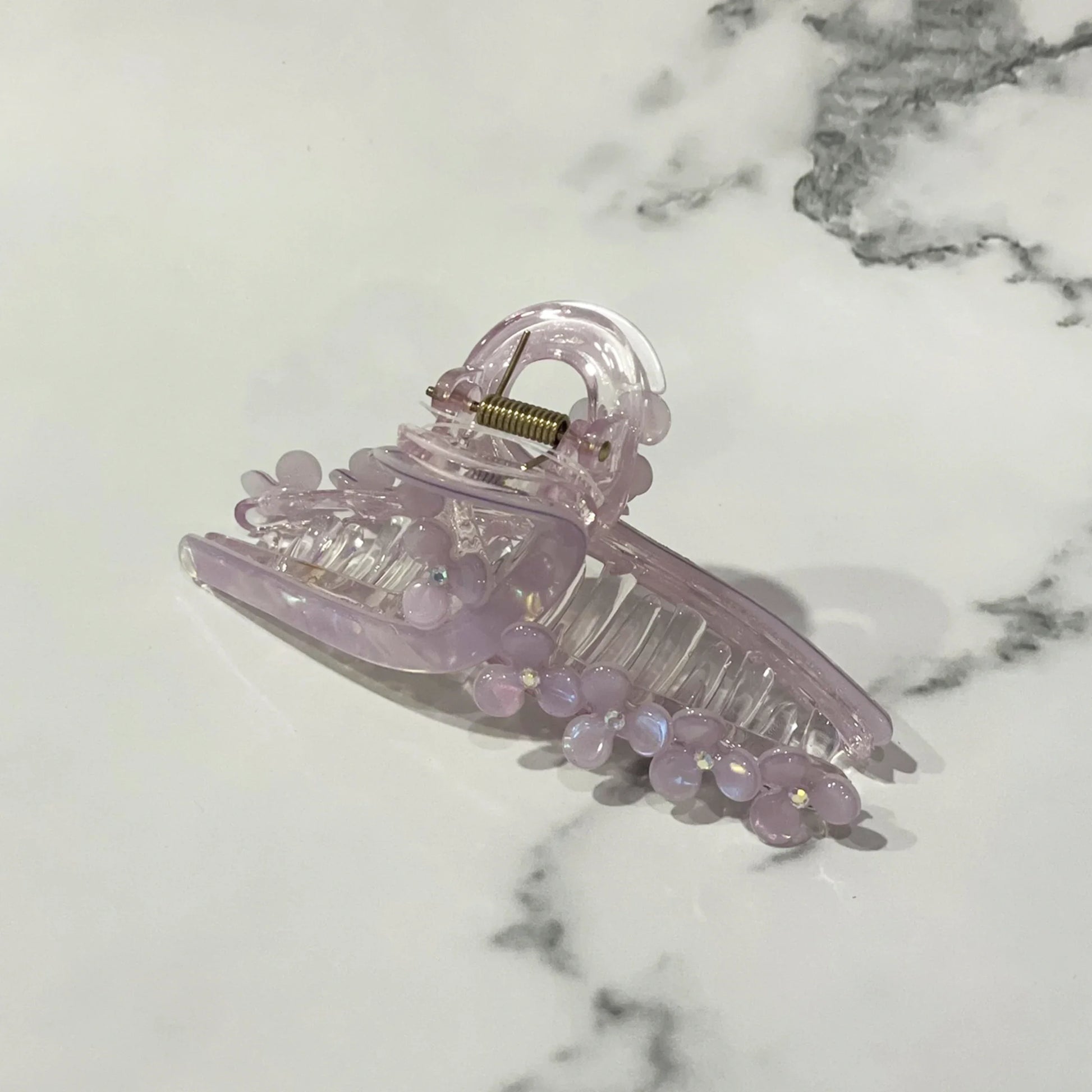 Light purple pearl floral hair clutches with translucent design on marble background