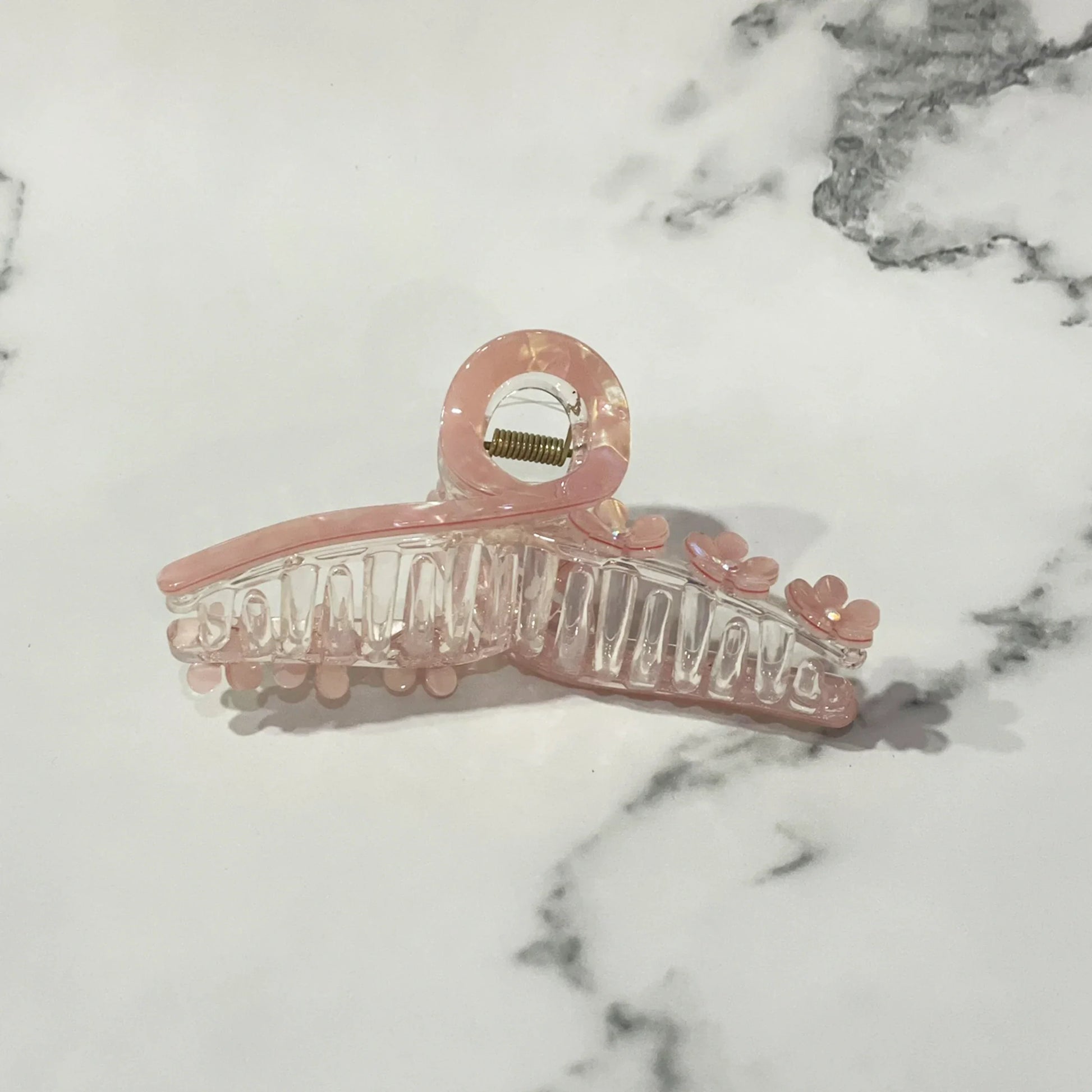 Pink pearl floral hair clutches with small flower details on a white marble surface