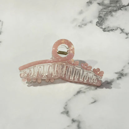 Pink pearl floral hair clutches with small flower details on a white marble surface