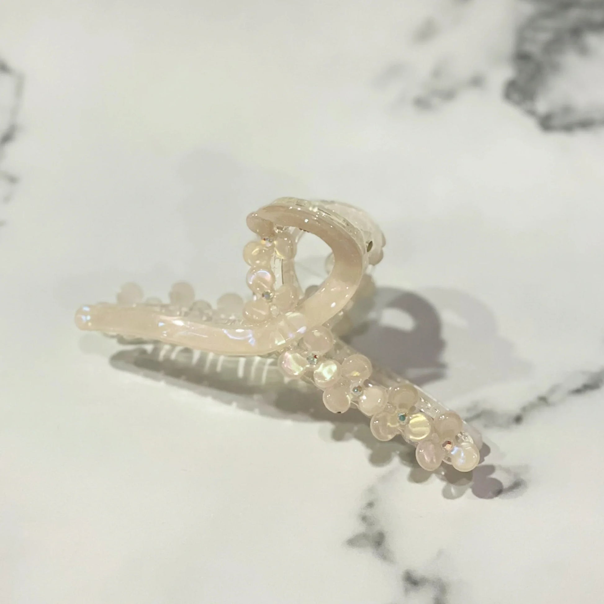 Elegant pearl floral hair clutches with translucent beads on a marble surface