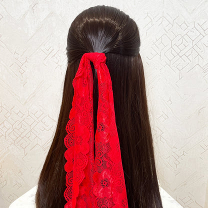 Bella Luxe red lacy hair scarf tied to long dark hair with intricate floral lace pattern