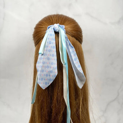 Light blue scrunchies with ribbon for women tied in long hair with patterned and solid color ribbons