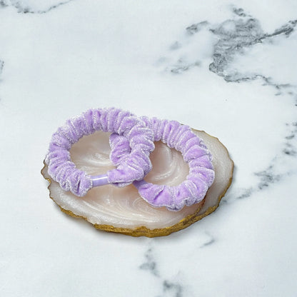 Lavender shiny velvet hair ties displayed on a polished agate stone with gold edges