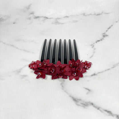 Black studded hair bun comb with red floral decoration and small embedded gems