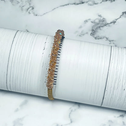 Brown studded headbands with small decorative beads displayed on white textured background