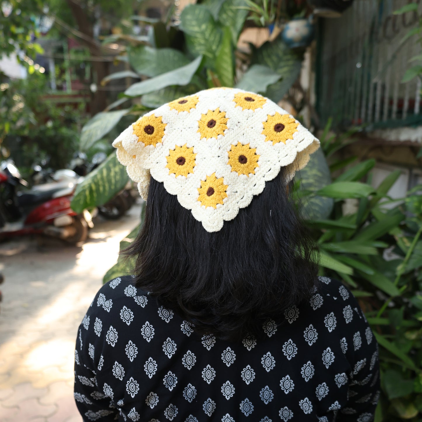 Bella Luxe sunflower crochet bandana worn on back of head with yellow and white floral pattern