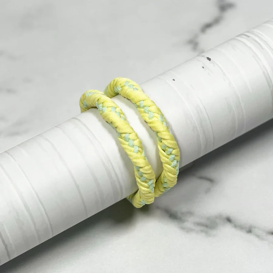 Yellow braided Thick Hair Ties displayed on white cylindrical holder for strong hair hold