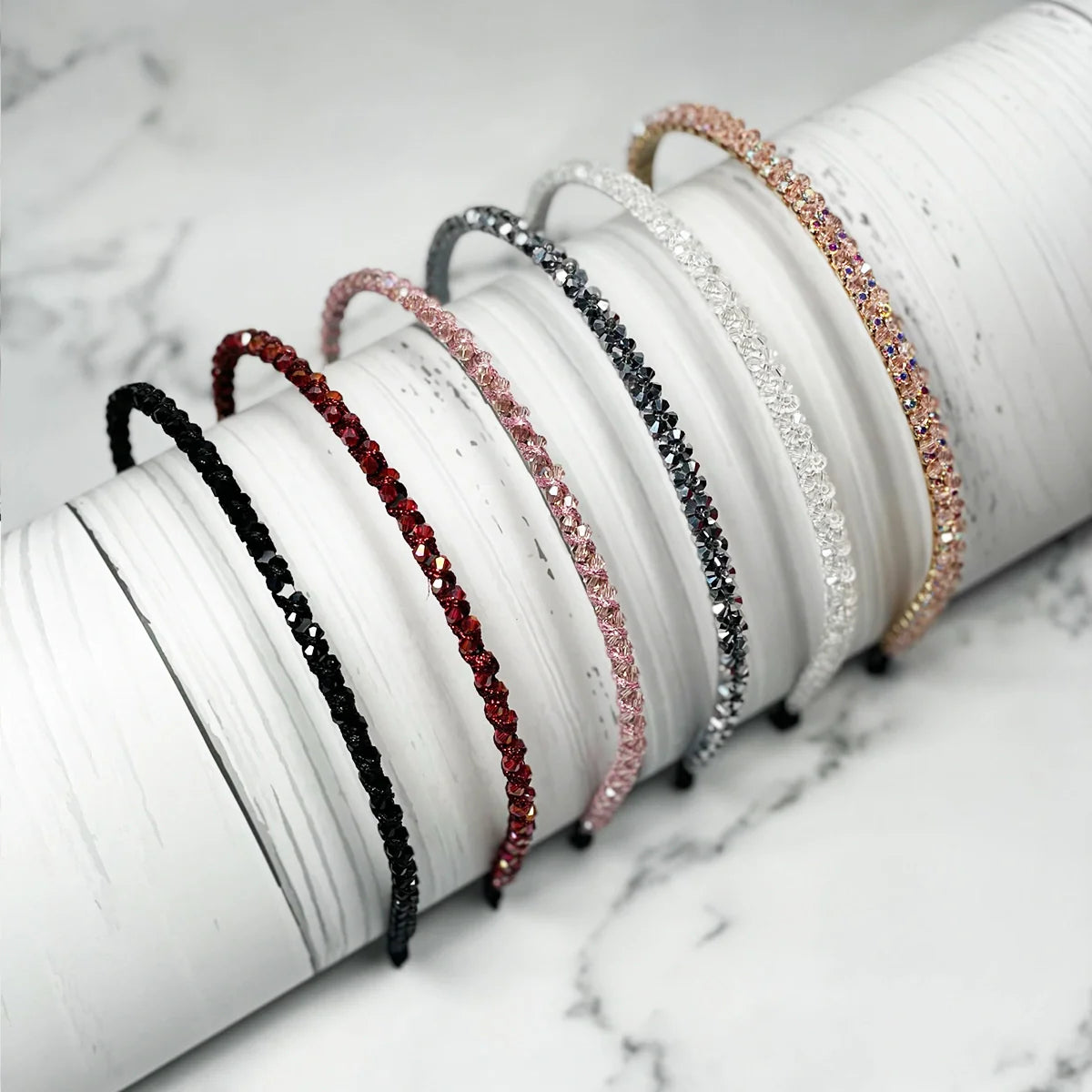 Thin embellished headbands for women in various colors with sparkling stones on white background
