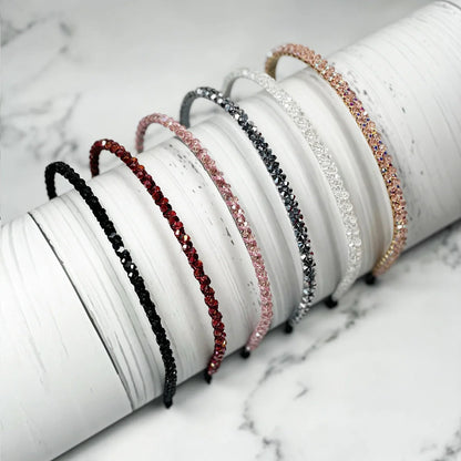 Thin embellished headbands for women in various colors with sparkling stones on white background