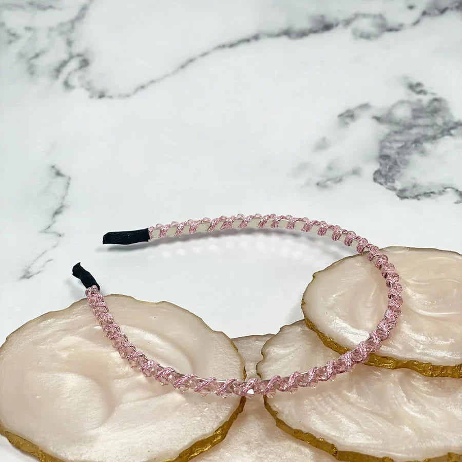 Pink thin embellished headbands for women with delicate detailing on a marble background