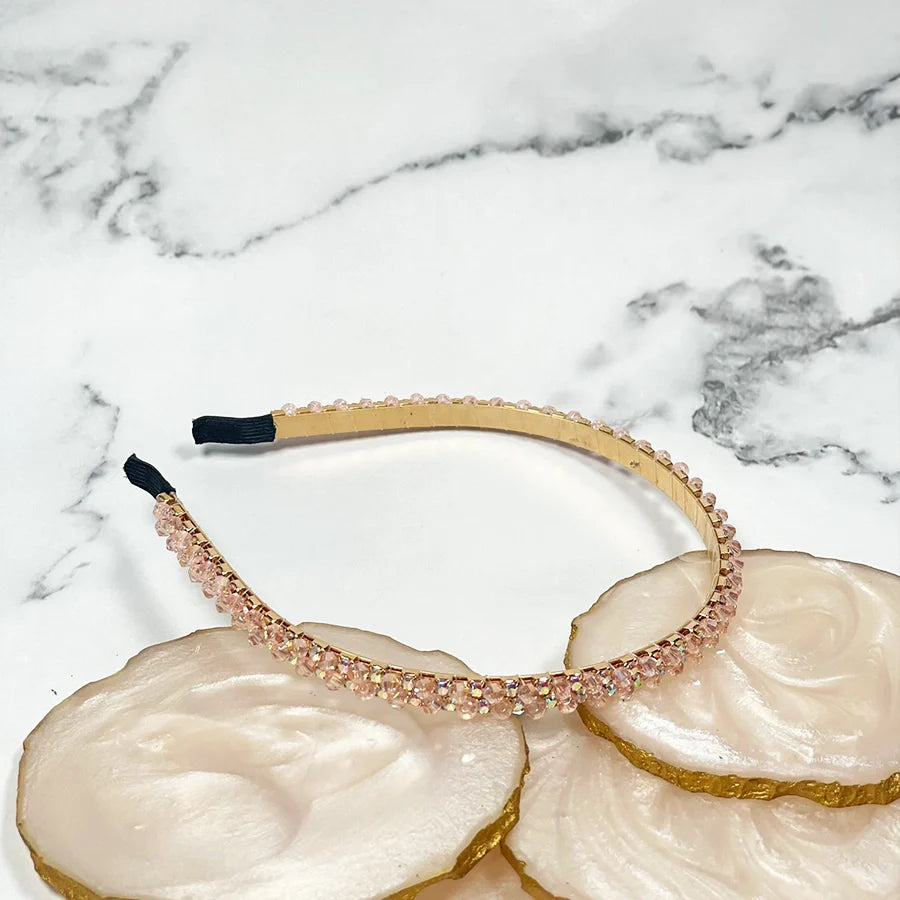 Thin embellished headbands for women with sparkling pink crystals on a beige base
