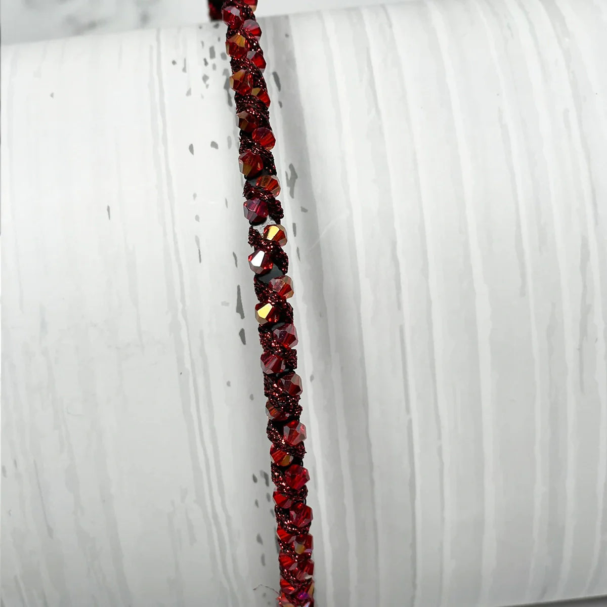 Close-up of thin embellished headbands for women with red sparkling stones on a white background