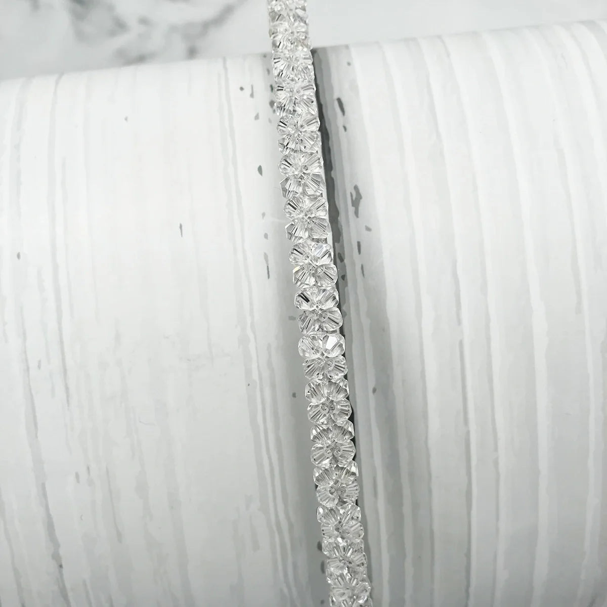 Elegant thin embellished headbands for women with clear floral crystal design on white background