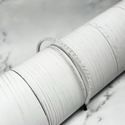Thin embellished headbands for women with sparkling crystals on a white textured surface