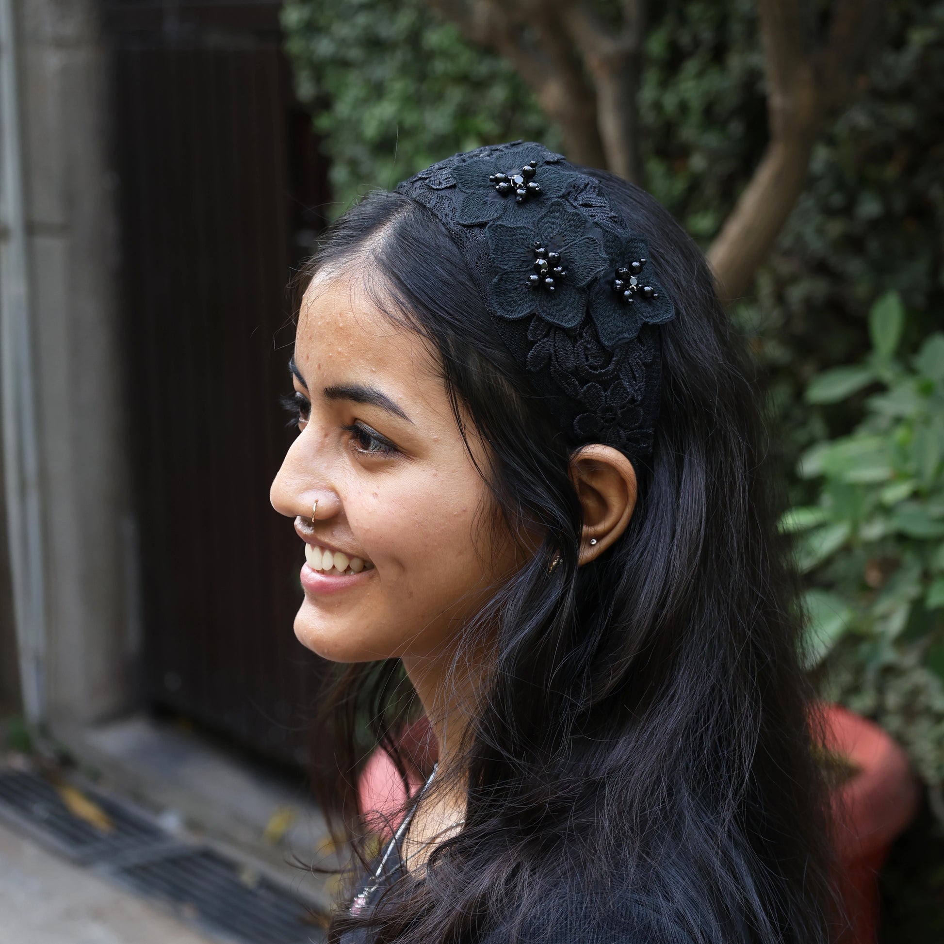 Black three flower broad hairbands worn by smiling woman with long dark hair outdoors