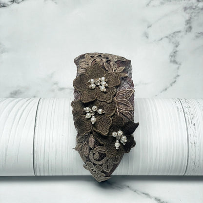 Three flower broad hairbands featuring brown lace and pearl embellishments on a white wooden background