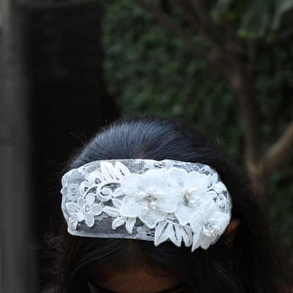 White lace three flower broad hairbands with pearl embellishments worn on dark hair