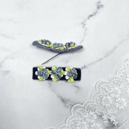 Velvet flower hair pins in blue and green with small fabric roses on a white lace background