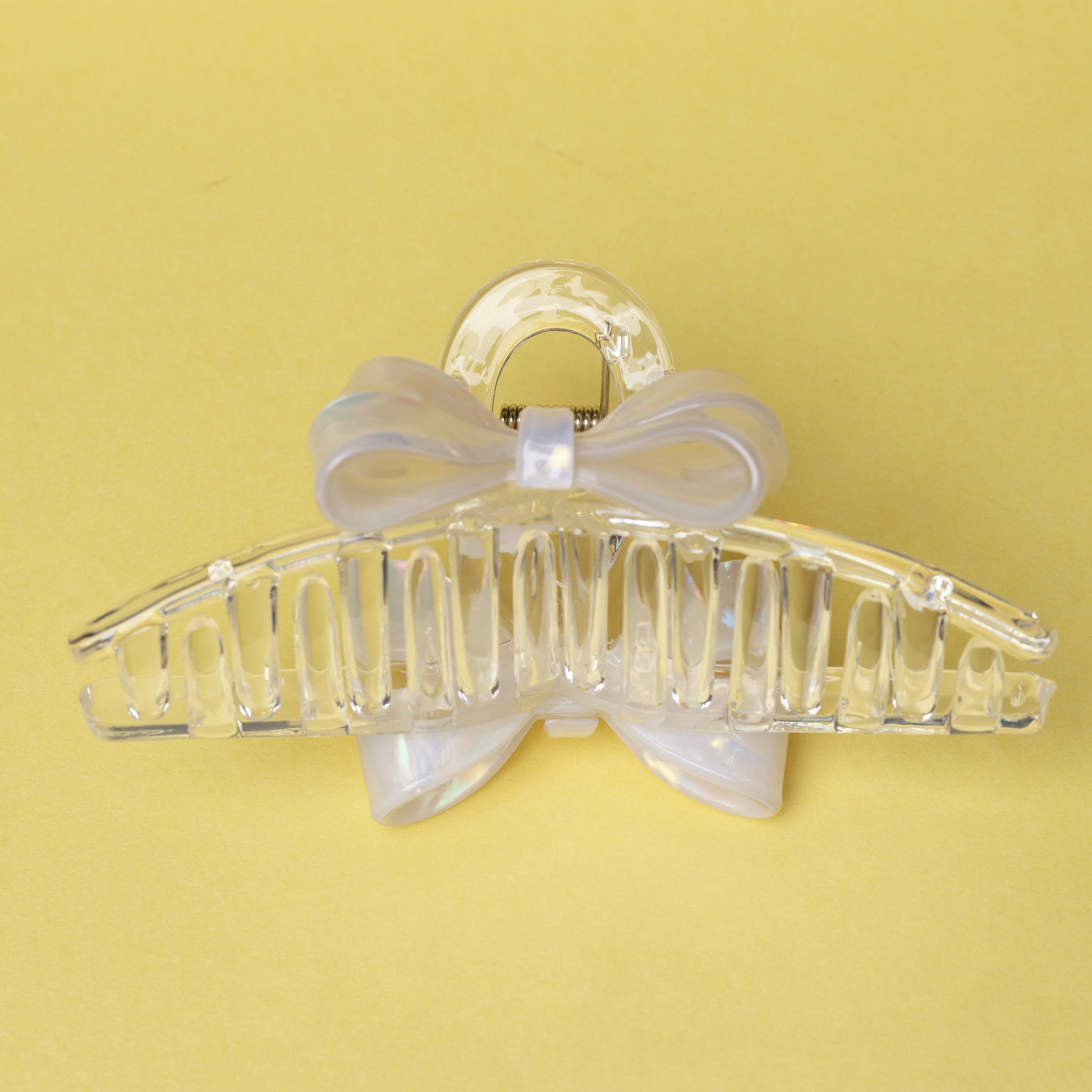 Clear plastic bow hair clutches with a decorative bow detail on a yellow background