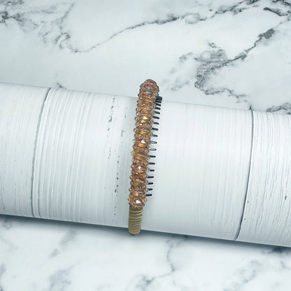Elegant heavy crystal embellished hairbands in light amber with a sparkling design on white wooden surface