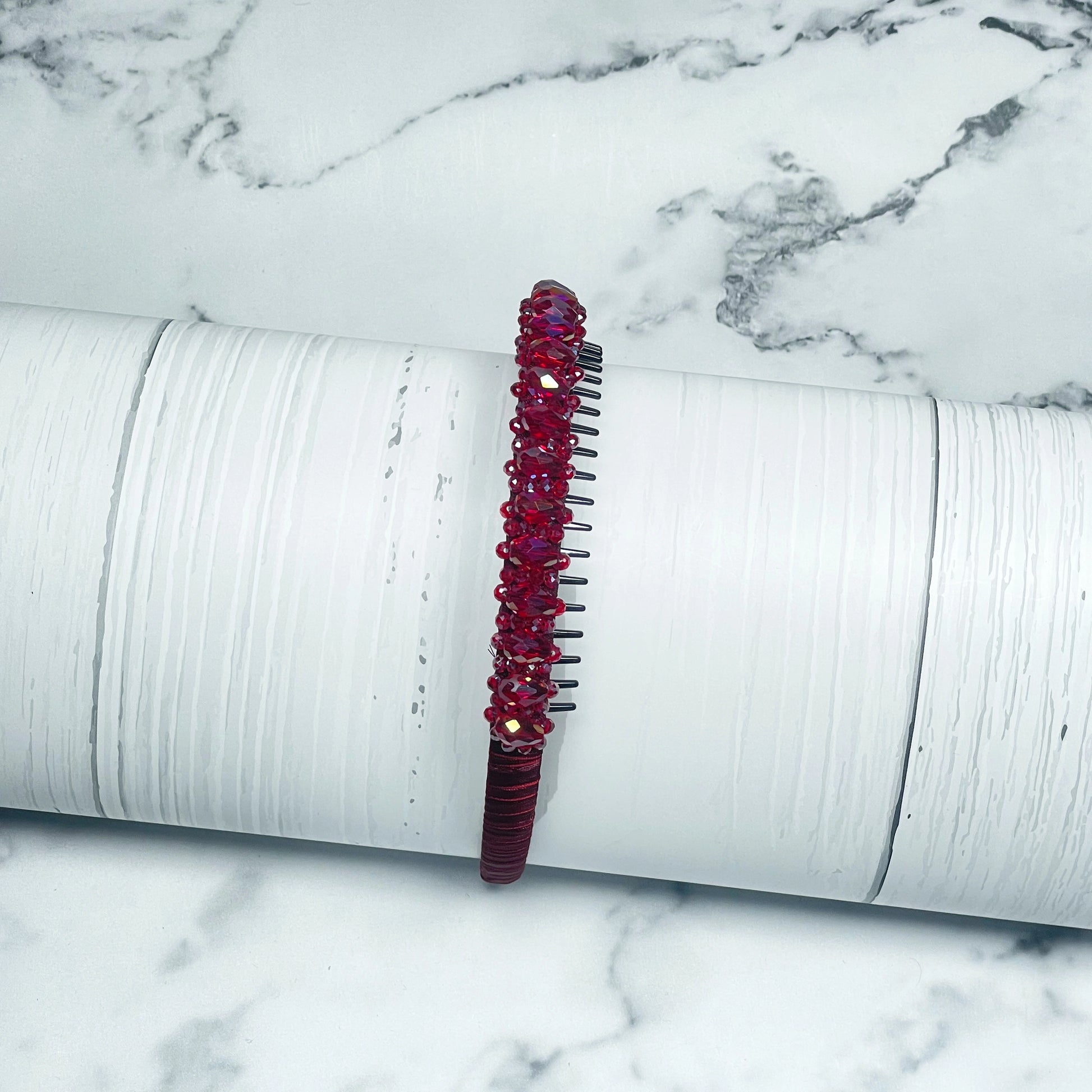 Red Heavy Crystal Embellished Hairbands with shiny beads on a textured white surface