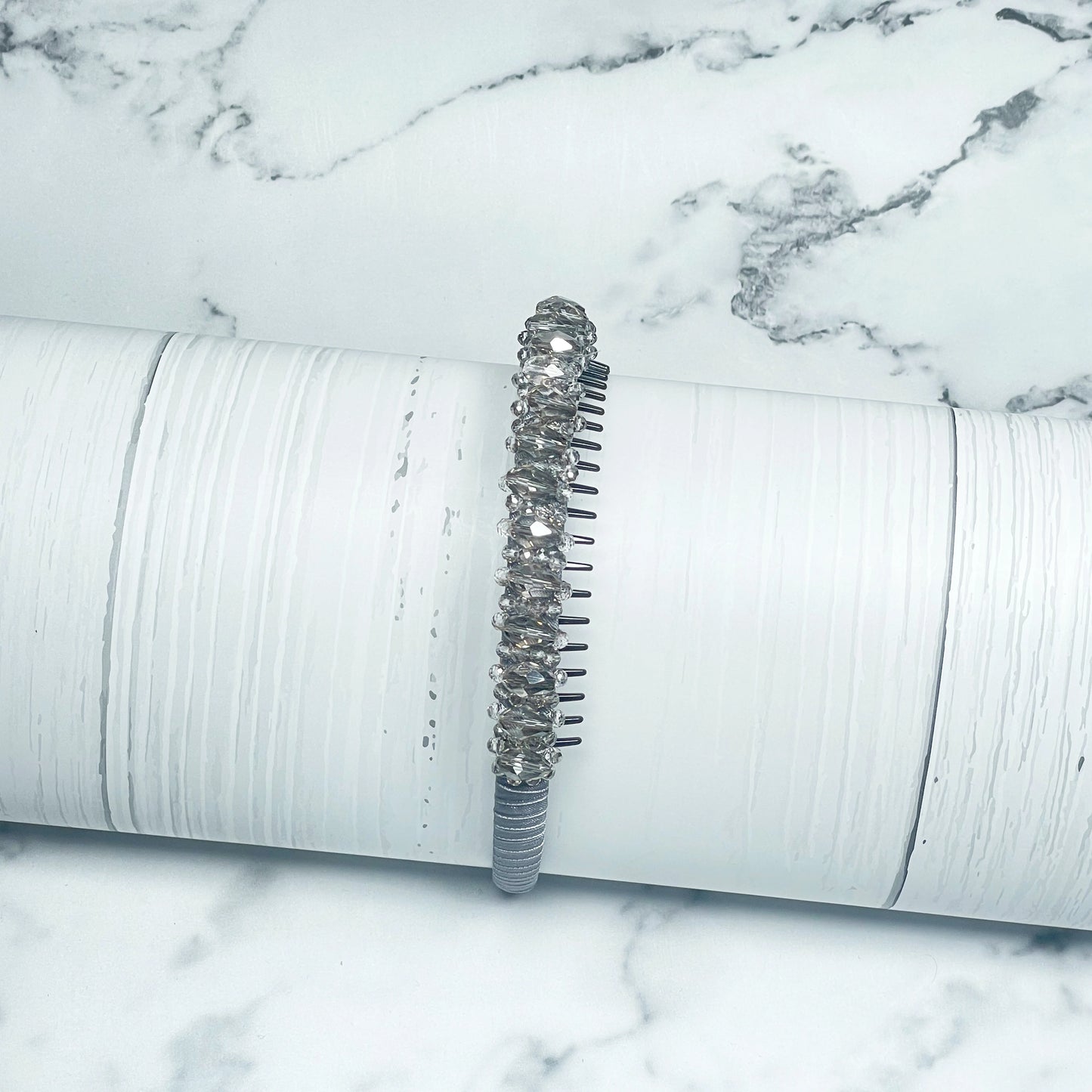 Heavy Crystal Embellished Hairbands with sparkling crystals on a white textured display stand