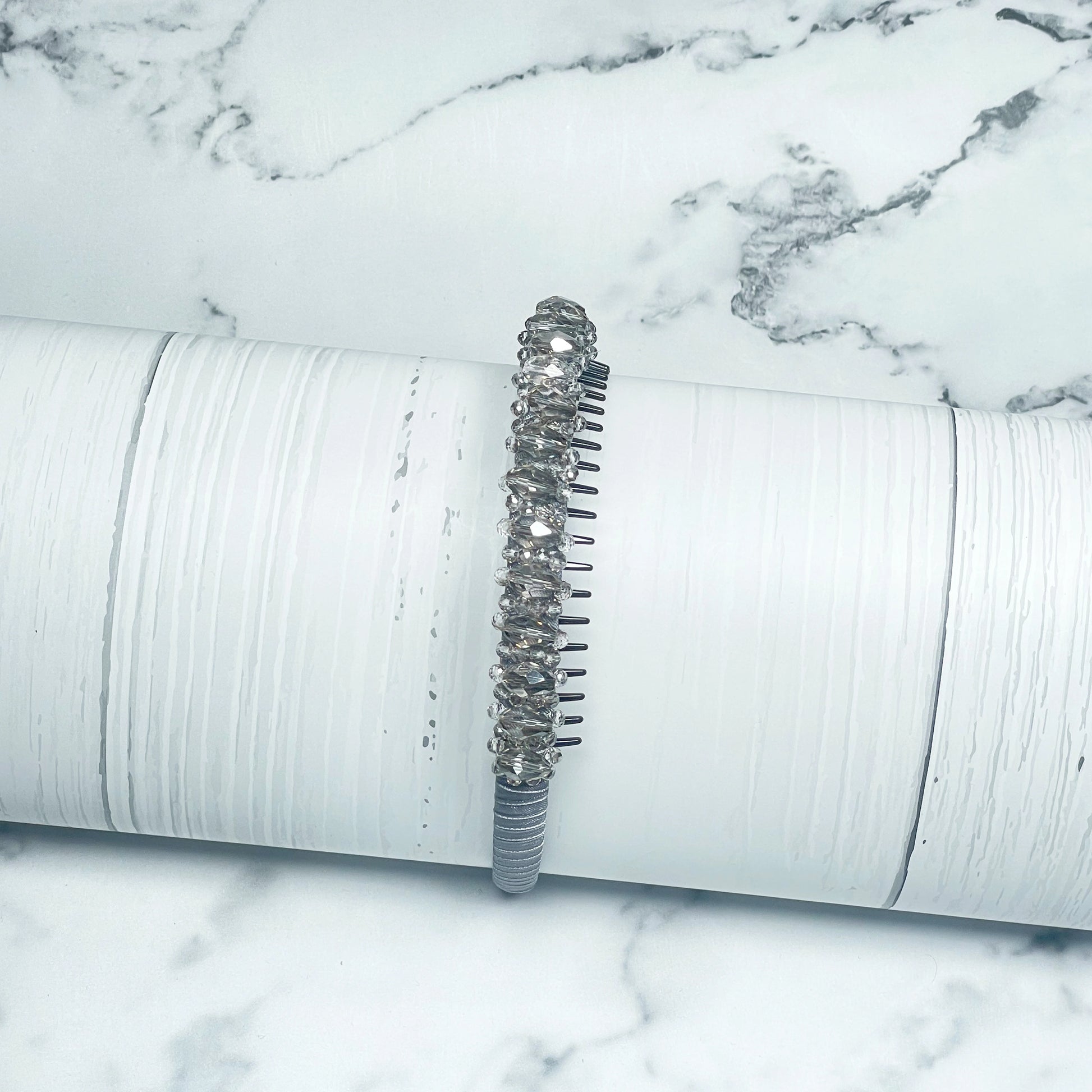 Heavy Crystal Embellished Hairbands with sparkling crystals on a white textured display stand
