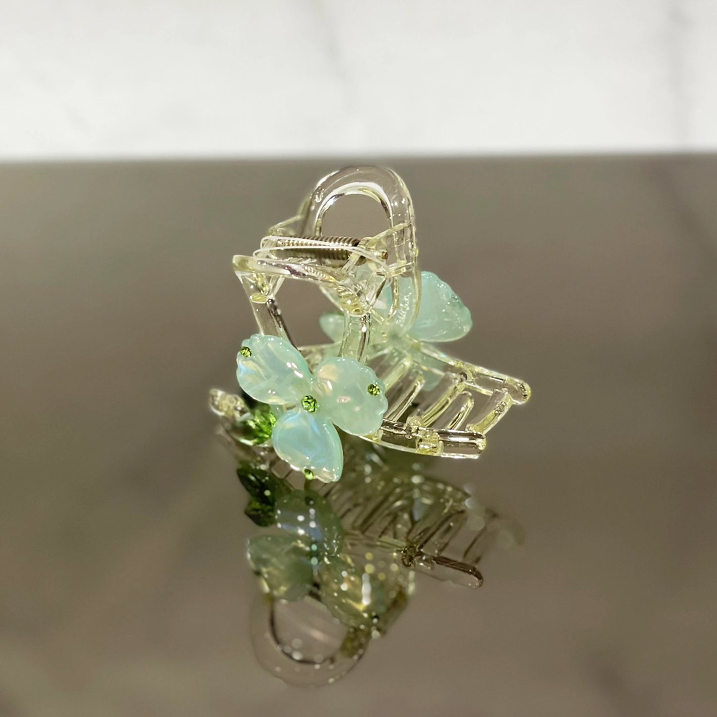 Clear hair clutch with pearl studded flower hair clutch design in soft blue petals and green centers