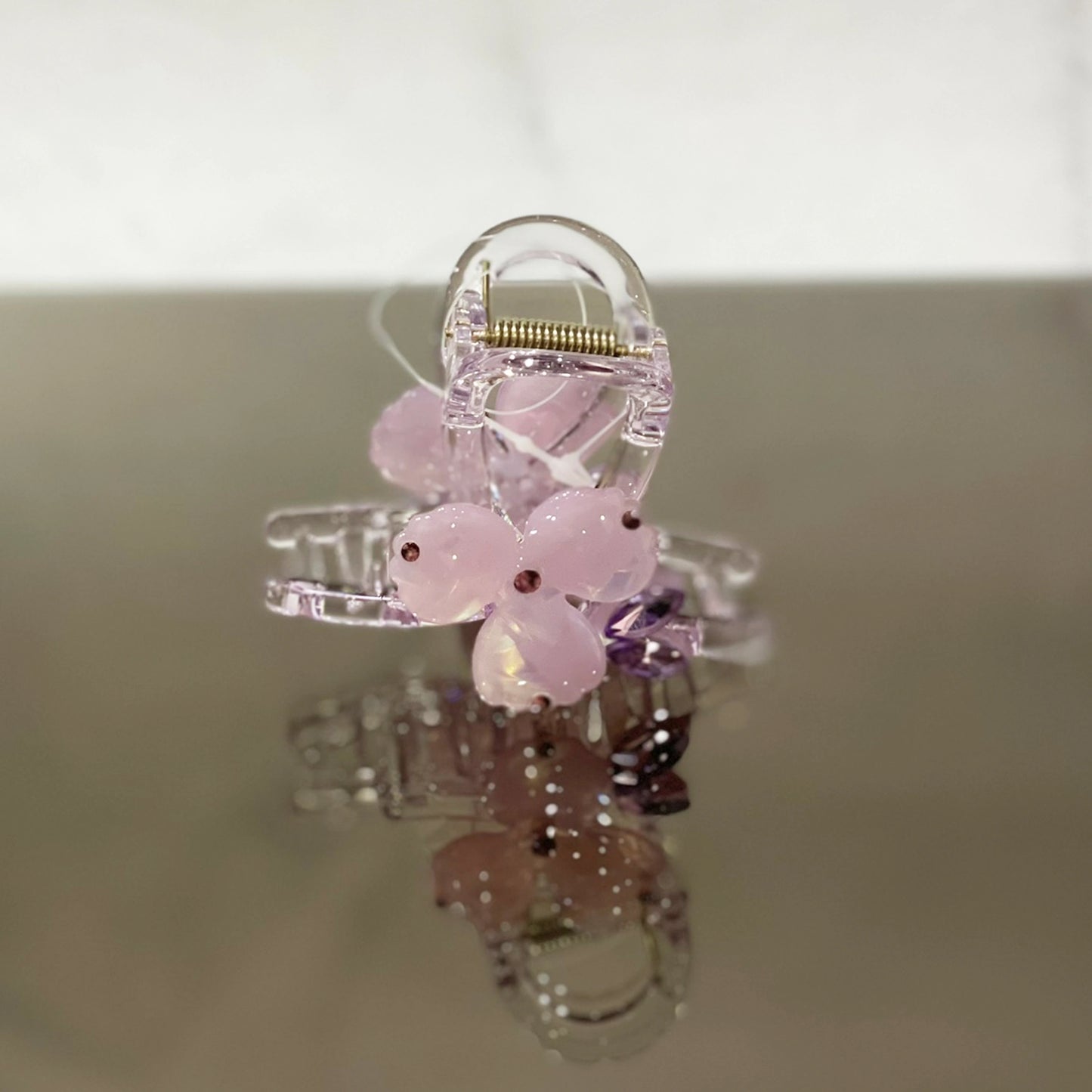 Clear hair clutch with pink pearl studded flower design for elegant hair styling