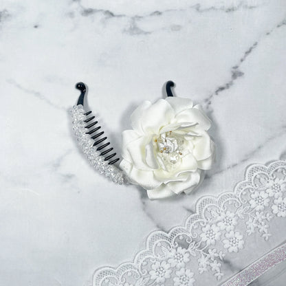 Bella Luxe white crystal banana clip with decorative white flower on marble background