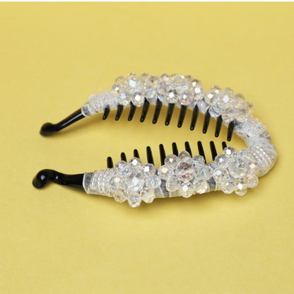 Bella Luxe white crystal studded banana clip with black teeth on a yellow background